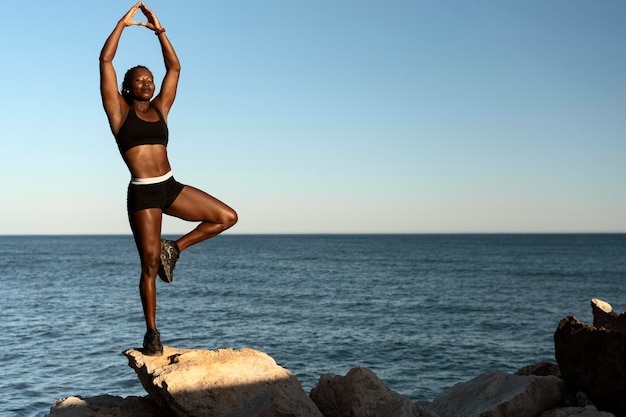 Vrouw staat aan het ene been met gesloten ogen tijdens het beoefenen van yoga