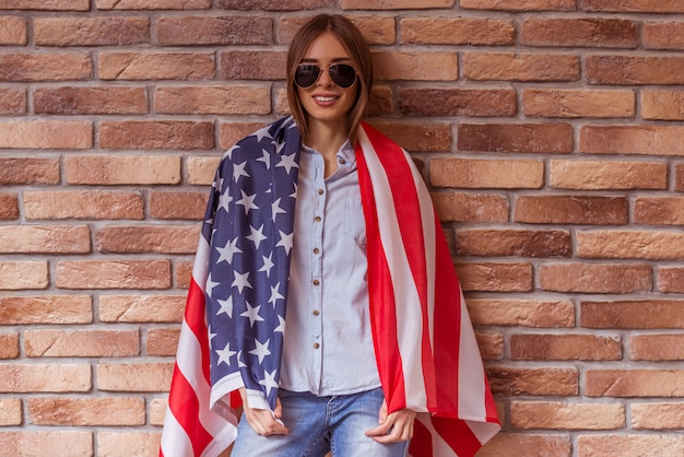 Vrouw staat bedekt met amerikaanse vlag.