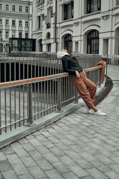 vrouw staat bij het hek op de brug in de stad.