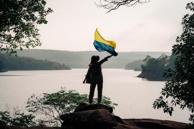 Vrouw staat en houdt de vlag van Oekraïne vast Save Oekraïne stop oorlog