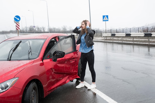 Vrouw staat in de buurt van een kapotte auto na een ongeval. roep om hulp. autoverzekering