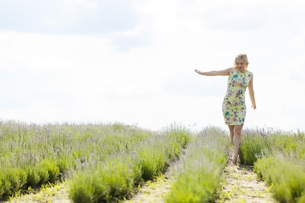 Vrouw staat met open armen op een lavendelveld