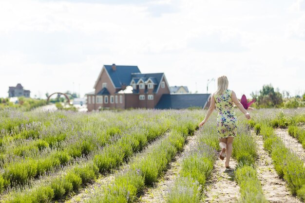 Vrouw staat met open armen op een lavendelveld