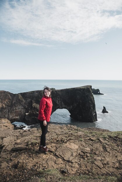 Vrouw staat op een klif in IJsland