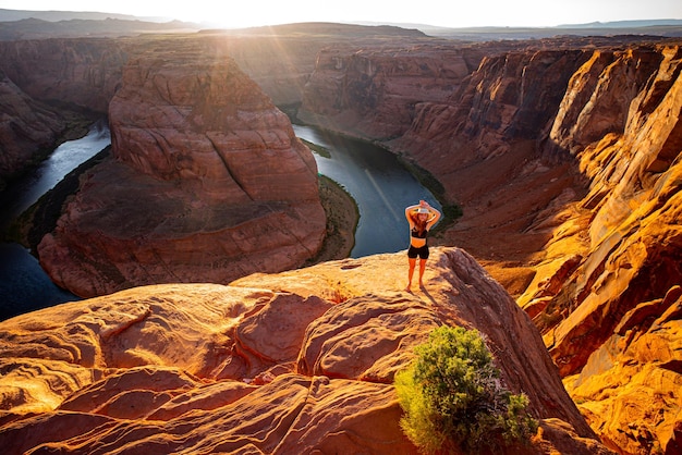 Vrouw staat over de rand van Horseshoe Bend. Grand Canyon, VS. Reizen en avontuur concept.