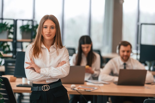 Vrouw staat voor haar collega's zakenlieden in formele kleren werken samen in het kantoor