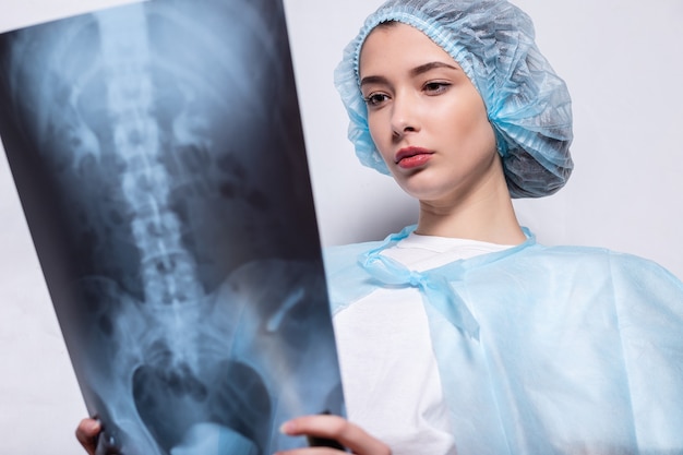 Vrouw steekt haar hand op en houdt een röntgenfoto arts geneeskunde, vrouw steekt haar hand op en houdt een röntgenfoto arts geneeskunde