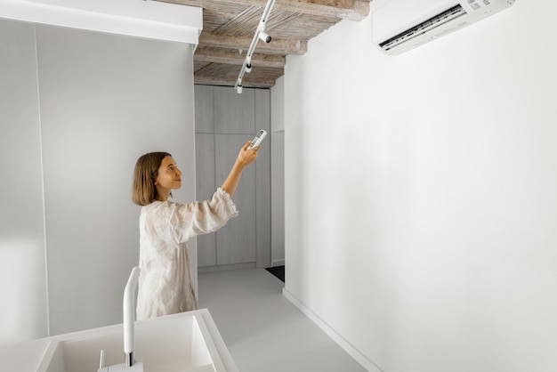 Vrouw stelt thuis de temperatuur in op de airconditioner