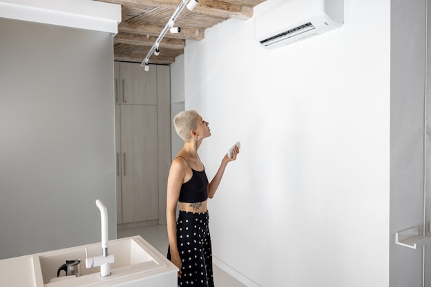 Vrouw stelt thuis de temperatuur in op de airconditioner