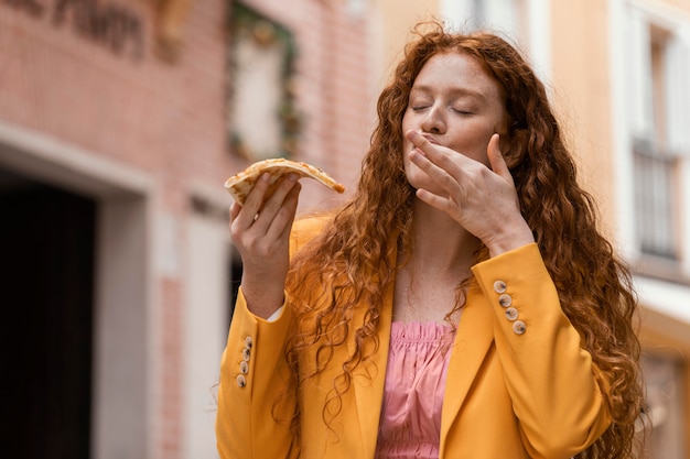 Foto vrouw straat eten buitenshuis