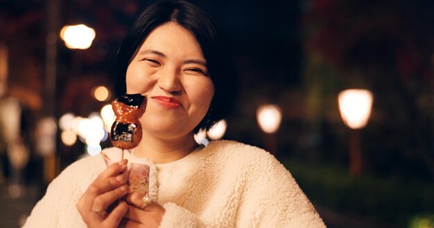 Vrouw straatvoeding en het eten van Japanse snacks voor toeristische ervaring hongerig of lokaal Vrouwelijke persoon gezicht en stoep's nachts voor mochi snoep voor stadsvakantie of cultuur avontuur of traditie