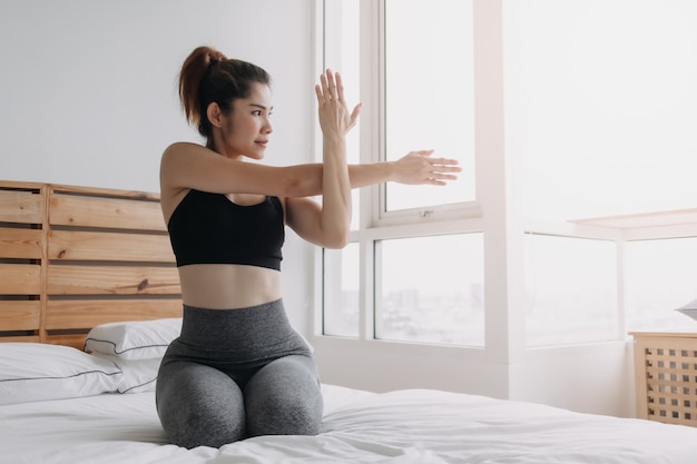 Vrouw strekt zich uit en koelt af na het sporten in haar appartementkamer