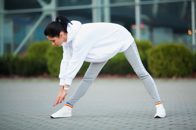 Vrouw stretching body, doen oefeningen op straat