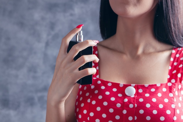 Vrouw strooit parfum in haar nek