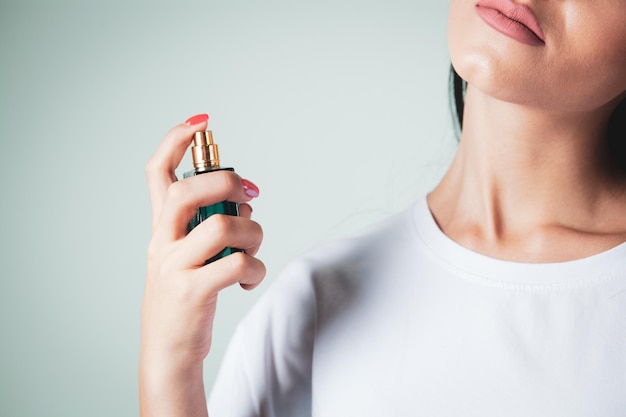 Foto vrouw strooit parfum in haar nek