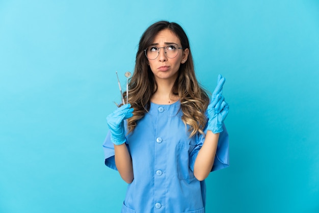 Vrouw tandarts tools poseren geïsoleerd tegen de blinde muur