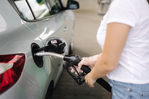 Vrouw tankt bij tankstation vrouwelijke hand vult benzine benzine brandstof in auto benzineprijzen