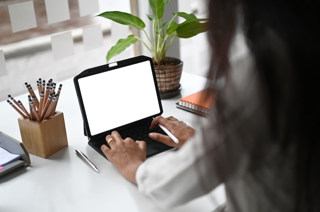Vrouw te typen op een witte lege scherm computertablet in het kantoor