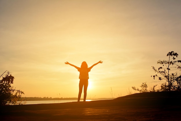 Vrouw tegen de hemel bij zonsondergang