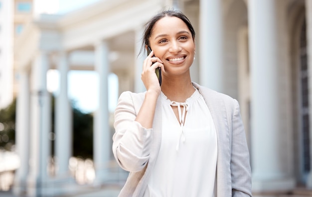 Vrouw telefoontje en glimlach voor communicatie in de stad met een gesprek over zakenreizen in de buitenlucht Vrouw glimlachend reizen en succes in 5G-oproepservice op mobiele smartphone