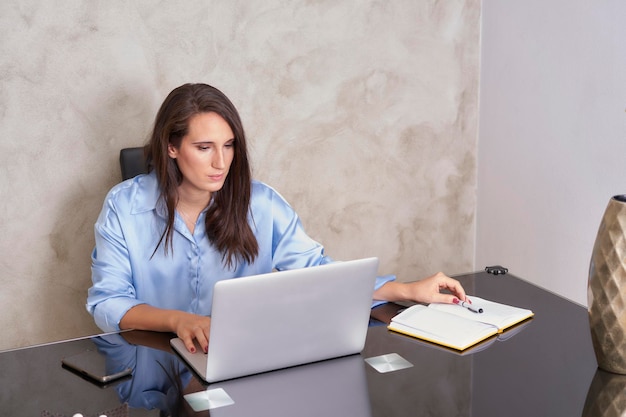 Vrouw telewerken vanuit huis aan bureau