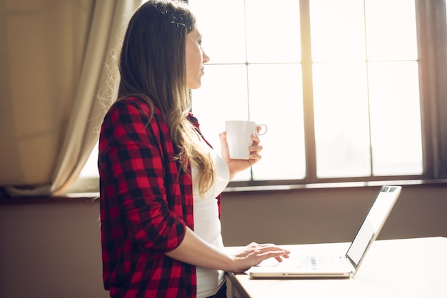 Vrouw telewerker werkt thuis met een laptop. slim werkconcept