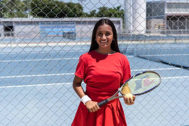 Vrouw tennisser houdt haar racket en tennisbal vast