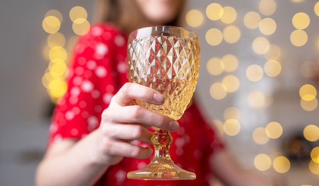 Vrouw thuis ingericht voor kerst bedrijf glas wijn en cheers close-up.