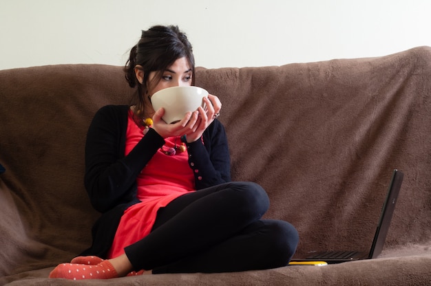 Foto vrouw thuis met beker