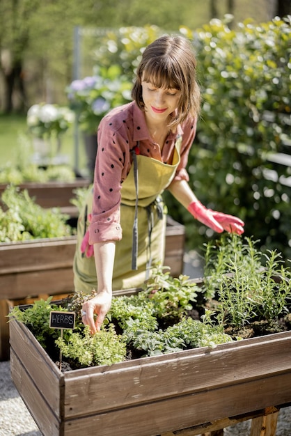 Vrouw thuis moestuin in de achtertuin van haar huis