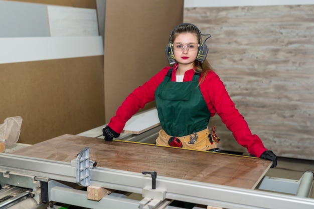Vrouw timmerman maatregel houten plank in werkplaats