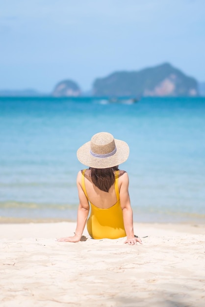 Vrouw toerist in gele zwembroek en hoed gelukkige reiziger zonnebaden op Paradise strand op eilanden bestemming reislust Azië reizen tropische zomervakantie en vakantie concept