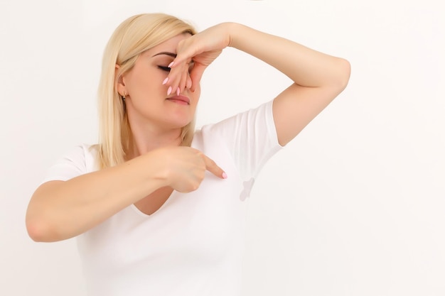 vrouw toont een vlek op haar witte t-shirt