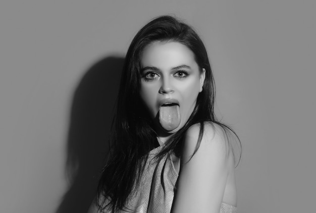 Vrouw toont tong Model met uitgestoken tong Meisje toont tong Emotionele mond met likkende lippen