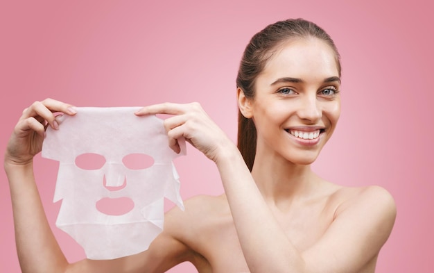 Vrouw toont voedend masker voor het verjongen en elimineren van defecten Acne