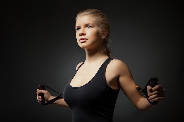 Vrouw trainen met weerstandsband op dark