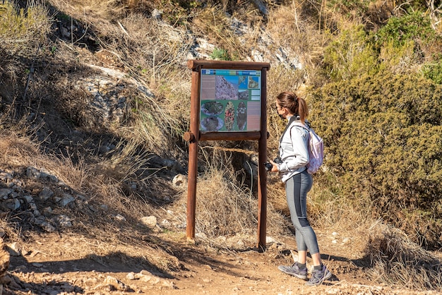 Vrouw trekt langs een pad in het natuurpark van peñon de ifach in calpe, in sportkleding