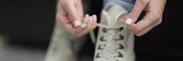 Vrouw trok haar witte laarzen aan en knoopte veters voordat ze naar buiten ging