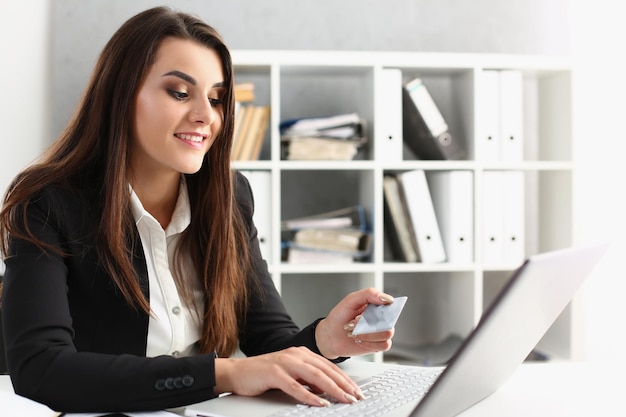 Vrouw type op toetsenbord creditcard pincode betalen online winkelen op laptop vanaf het werk