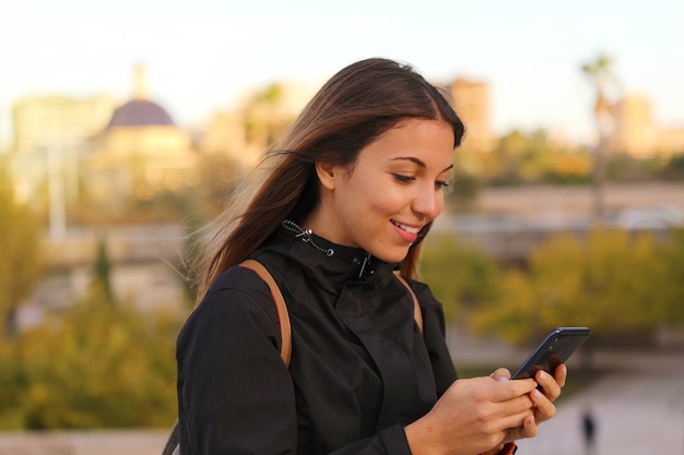 Vrouw typen berichten met slimme telefoon buiten