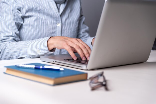 Vrouw typen op een computer boek brillen kopieer ruimte leesonderwijs concept selectieve focus