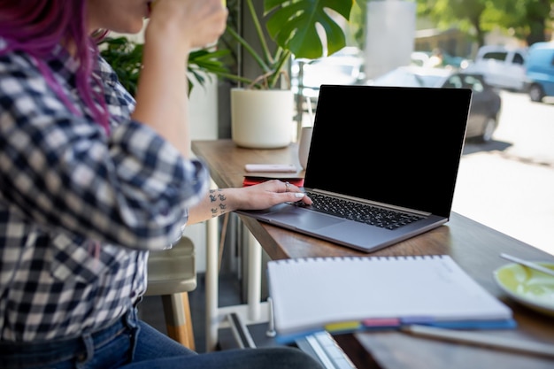 Foto vrouw typen op notebook met leeg scherm met kopie ruimte voor uw tekst of reclame-inhoud zitten...