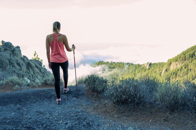 Foto vrouw van achteren bovenop de berg wandelen