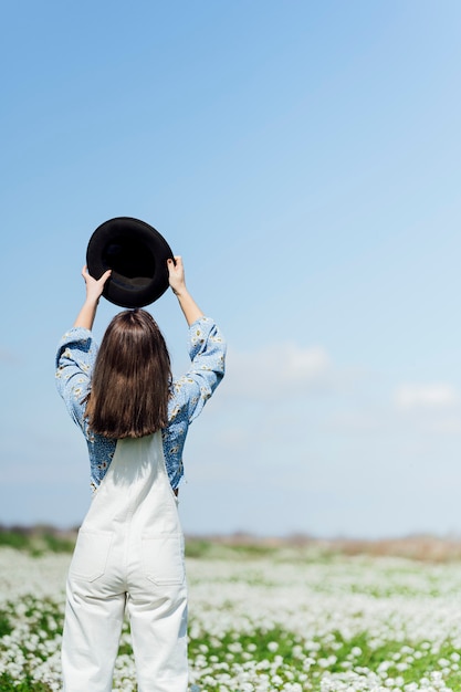 Vrouw van achteren met hoed in veld