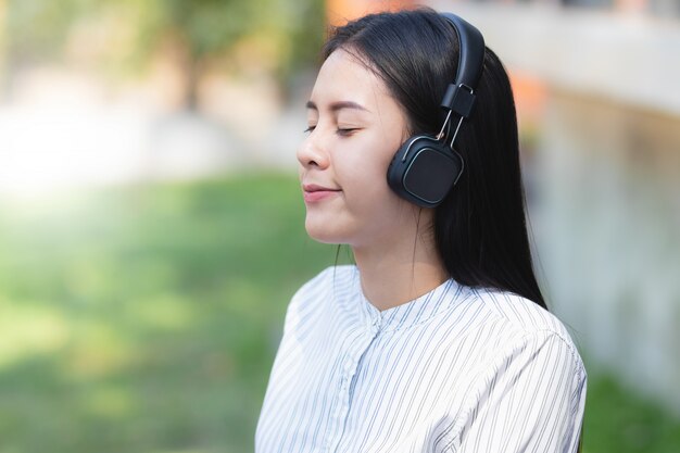 Vrouw van Azië het luisteren aan muziek met ontspant en gelukkig op vakantie.