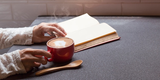 Vrouw van handen met warme kop koffie latte