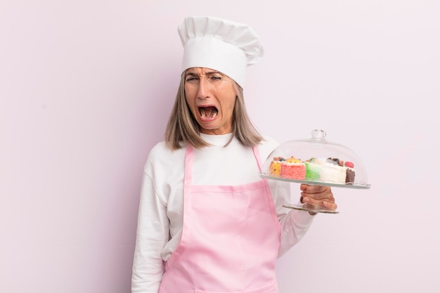 Vrouw van middelbare leeftijd die agressief schreeuwt en er erg boos uitziet als een bakker en gebakconcept