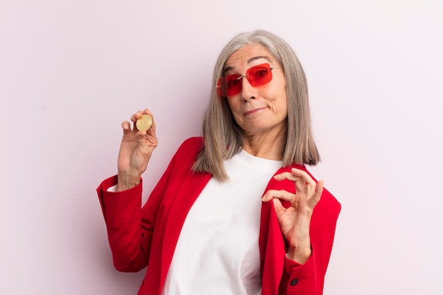 Vrouw van middelbare leeftijd die er arrogant, succesvol positief en trots bitcoin-concept uitziet
