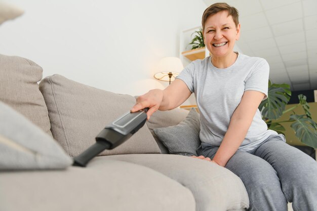 Vrouw van middelbare leeftijd die nieuw appartement schoonmaakt