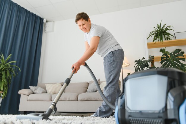 Vrouw van middelbare leeftijd die nieuw appartement schoonmaakt